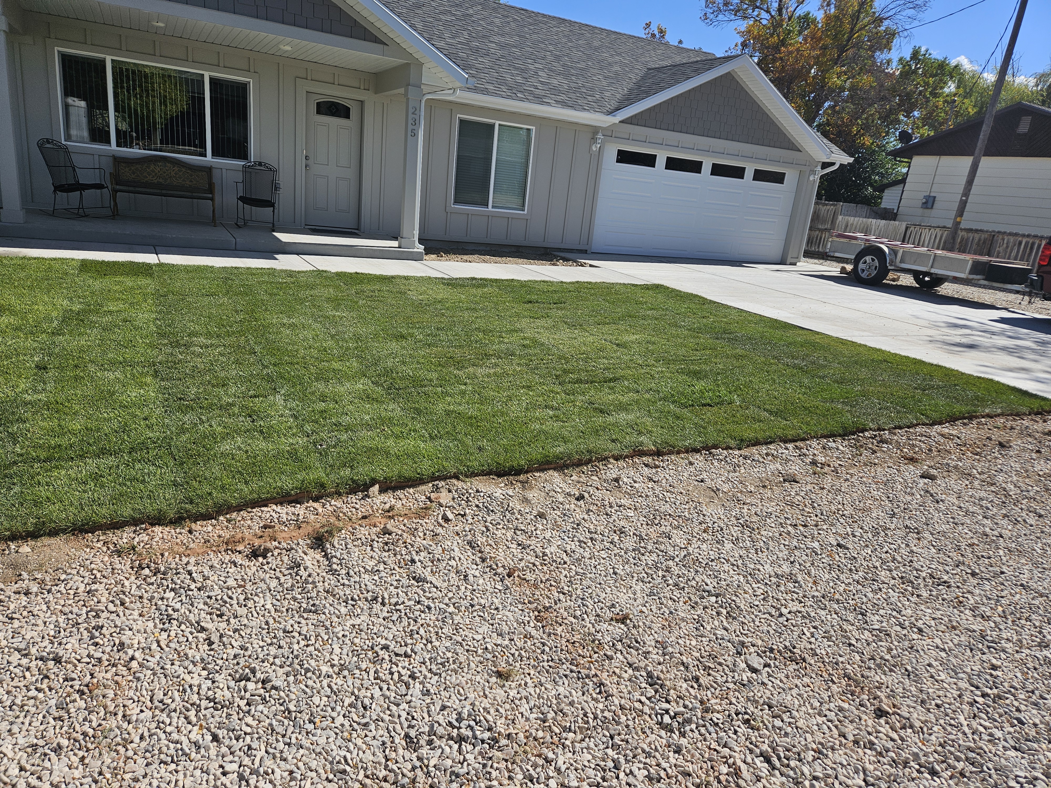 Concrete paver walkway leading to a front entrance with landscape plantings on both sides