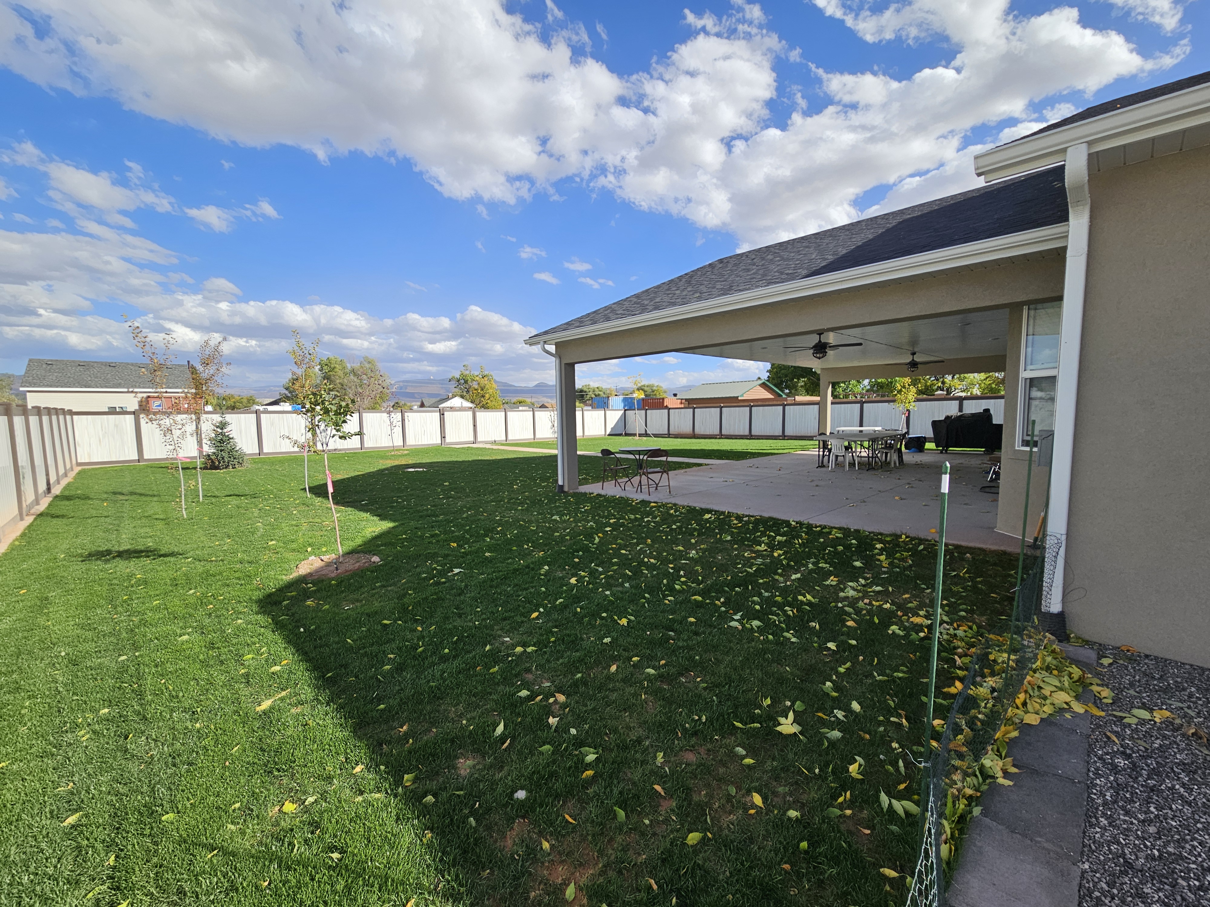 Backyard landscape renovation with sod, planting beds, retaining walls, and pathway lighting